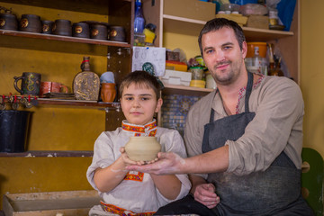 Potter showing how to work with ceramic in pottery studio