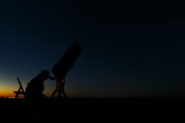 Telescope for the study of stars and planets. An astronomer makes observations in the open air.