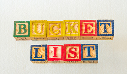 The term bucket list visually displayed on a white background using colorful wooden blocks image with copy space in landscape format © Richard