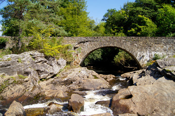 Fototapeta na wymiar Alte Steinbrücke neben den Falls of Dochart in Killin, Schottland