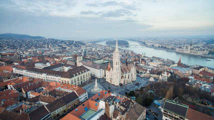Fototapeta premium Aerial skyline view of Matthias Church with Danube River and Parliament. Beautiful sunny day at Budapest, Hungary, Europe