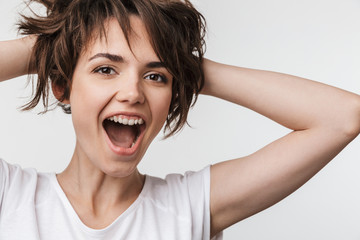 Pretty excited happy woman posing isolated over white wall background laughing.