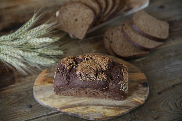 ​​rye bread and ears of rye on a wooden rustic background