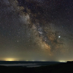 Stars in the sky at night. Bright milky way over the horizon with fog. Photographed with a long exposure.