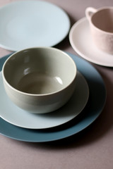 Collection of pottery and kitchenware in muted pastel colors. Selective focus.