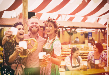 Freunde auf dem Oktoberfest im Bierzelt mit Maß Bier - obrazy, fototapety, plakaty