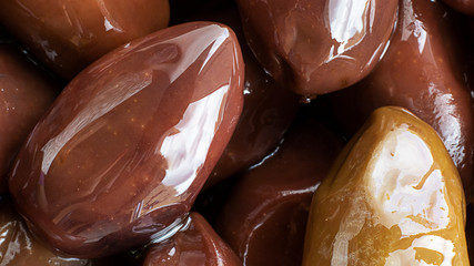Close up marinated kalamata olives, product of Greece and Cyprus in oil as background. horizontal banner. Macro.