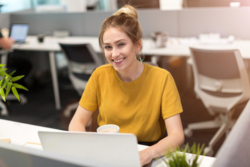 Young business woman working on laptop in office