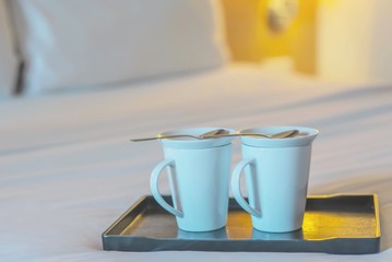 Close up of twin welcome coffee cup on white bed in hotel room - hotel well hospitality vacation travel concept