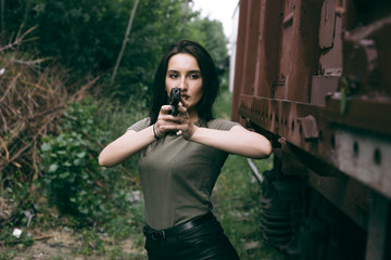Naklejka premium Powerful Woman Holding Gun Action Movie Style. Train adventure. Military girl with .