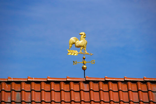 A golden weathercock on the roof on blue sky background, Castle Island Mirow, Mecklenburg Western Pomerania - Germany