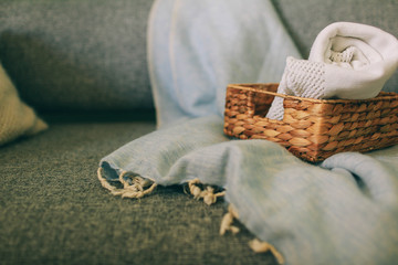 wicker basket with a blanket lying on the bed next to the candle home comfort and decor