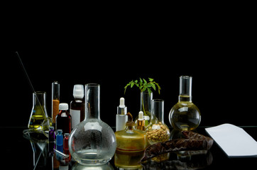 Medical jars with reagents and alcohol burner and a sheet of paper on a black background