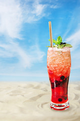 Cold fresh fruit summer cocktail by beach
