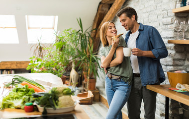 Happy couple eating breakfast together at home