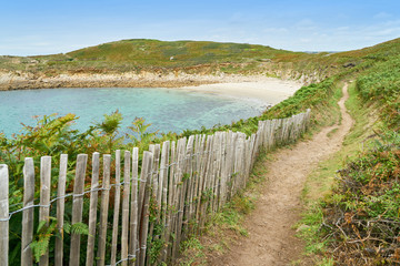 Fototapeta na wymiar Pfad mit Zaun zu Strand in Bucht in Bretagne
