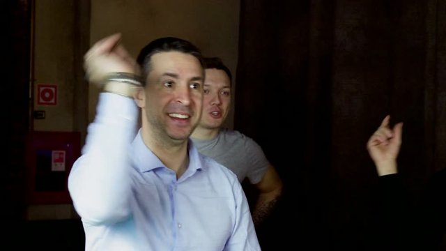 A group of men playing in game of darts, throwing a dart arrow in target center of dartboard. 4K
