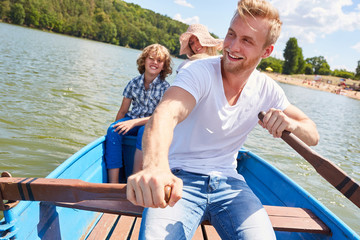 Fototapeta premium Happy father rows his family in the boat