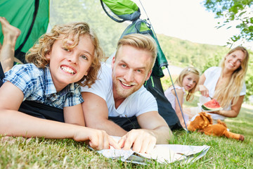 Father and son with map at camping