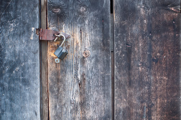 old padlock with keys on old wooden door