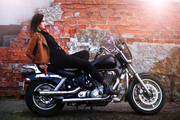 Plakat Portrait of beautiful young woman posing with motorcycle