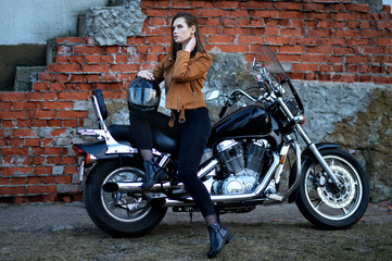 Fototapeta na wymiar Portrait of beautiful young woman posing with motorcycle