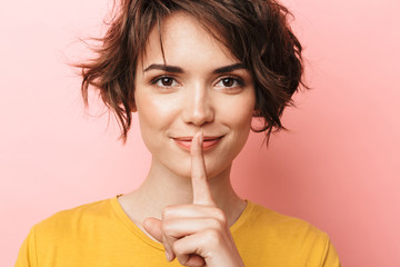 Happy beautiful woman posing isolated over pink wall background showing silence gesture. - obrazy, fototapety, plakaty