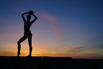 Fototapeta premium dancer in the dance does the splits in the air against the sunset