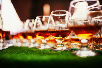 glasses with cognac, whiskey stand on the bar. a lot of glasses with cognac. alcohol in the glasses. Various alcohol drinks standing on bar. glasses with cognac on the bar
