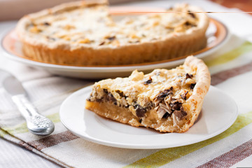 Slice of chicken tart with mushrooms and cheese on a plate