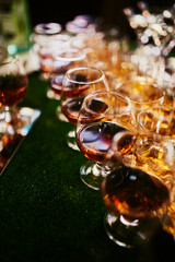 glasses with cognac, whiskey stand on the bar. a lot of glasses with cognac. alcohol in the glasses. Various alcohol drinks standing on bar. glasses with cognac on the bar