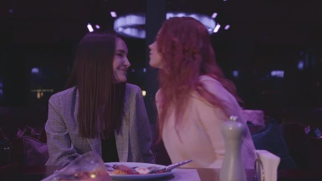 Cute young girl kisses the forehead of his beautiful girlfriend. Love and relationship concept