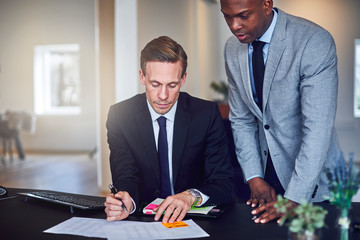 Two businessmen going over paperwork together in an office