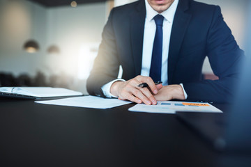 Businessman reading paperwork while sitting at his office desk