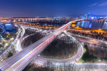 Fototapeta na wymiar Korea travel, Cars passing in intersection, Han River and bridge at Night in Downtown Seoul, South Korea.