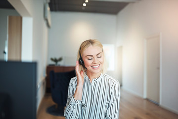 Young businesswoman laughing while talking on a headset at work