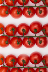 Fresh juicy red cherry tomato bunch closeup isolated on white background. 