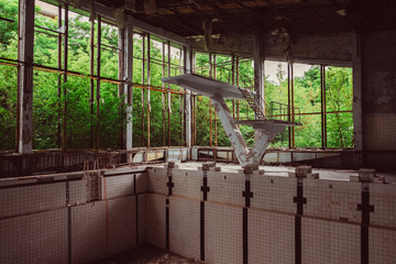 Old empty school swimming pool in destroyed abandoned ghost city Pripyat ruins after Chernobyl...
