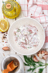 Preparation chicken fillet (nuggets) in a sauce of Greek yogurt with lemon, garlic, dill and spices. Rustic style. Selective focus