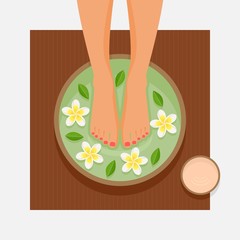 Spa foot therapy. Women's feet in bowl with flowers and leaves
