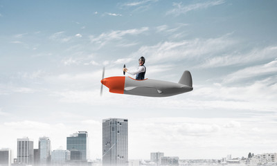 Pilot sitting in cabin of small airplane