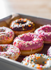 Assorted sweet donuts in a paper box.