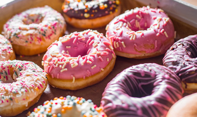 Assorted sweet donuts in a paper box.