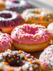 Assorted sweet donuts in a paper box.