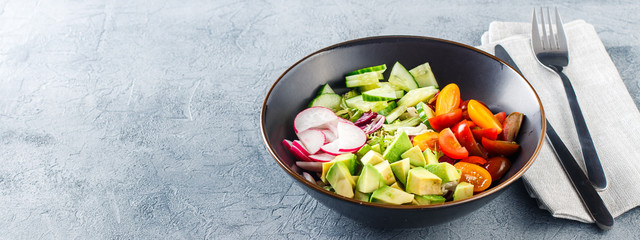 Vegan buddha bowl. Healthy vegetarian salad with cherry tomatoes, cucumber, radish,, avocado and lettuce.