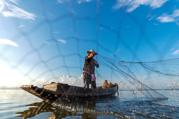Fisherman action when fishing net  on lake in the sunshine morning outdoors on the boat....