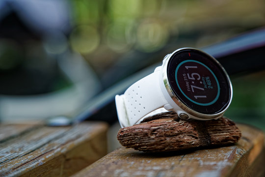 Close-up sport watch for running white color on wooden bench. Fitness watch for tracking daily activity and power training.