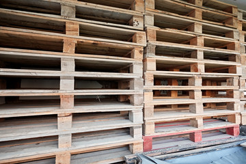 Fototapeta na wymiar old wooden transportation euro pallets in an outdoor warehouse