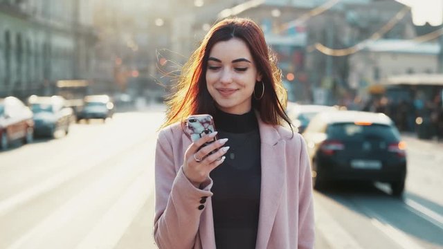 happy satisfied girl woman stand in busy timelapse city look around smiling use smatphone app fast moving traffic cars