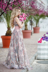 Beautiful woman in elegant evening dress.Blonde Girl with Long Healthy and curly hair. Beautiful...